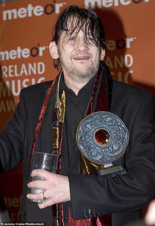 MacGowan in 2006, posing with a lifetime achievement award for his performances in The Pogues