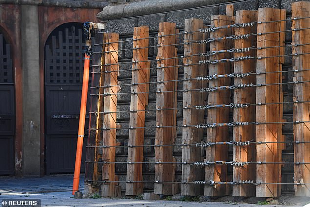 Rund um die Struktur sind Holzblöcke zu sehen, die mit Metalldrähten versiegelt sind, die angeblich den Turm an Ort und Stelle halten