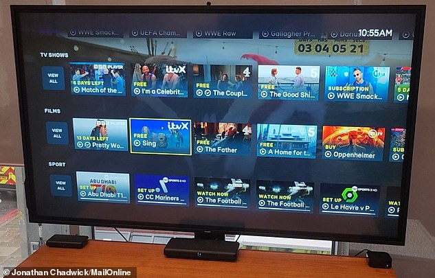 EE TV verfügt über ein bekanntes Scroll-Down-Menü und zahlreiche Karussells – viele davon trennen die verfügbaren Inhalte nach Kategorien, wie z. B. Sport und Filme.  Unter dem Bildschirm befinden sich drei Set-Top-Boxen – TV Box Pro (Mitte), TV Box Mini (links) und Apple TV 4K (rechts).