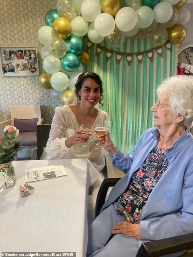 Hier ist Jean zu sehen, wie sie ein Glas erhebt, um auf den besonderen Tag ihrer Enkelin anzustoßen