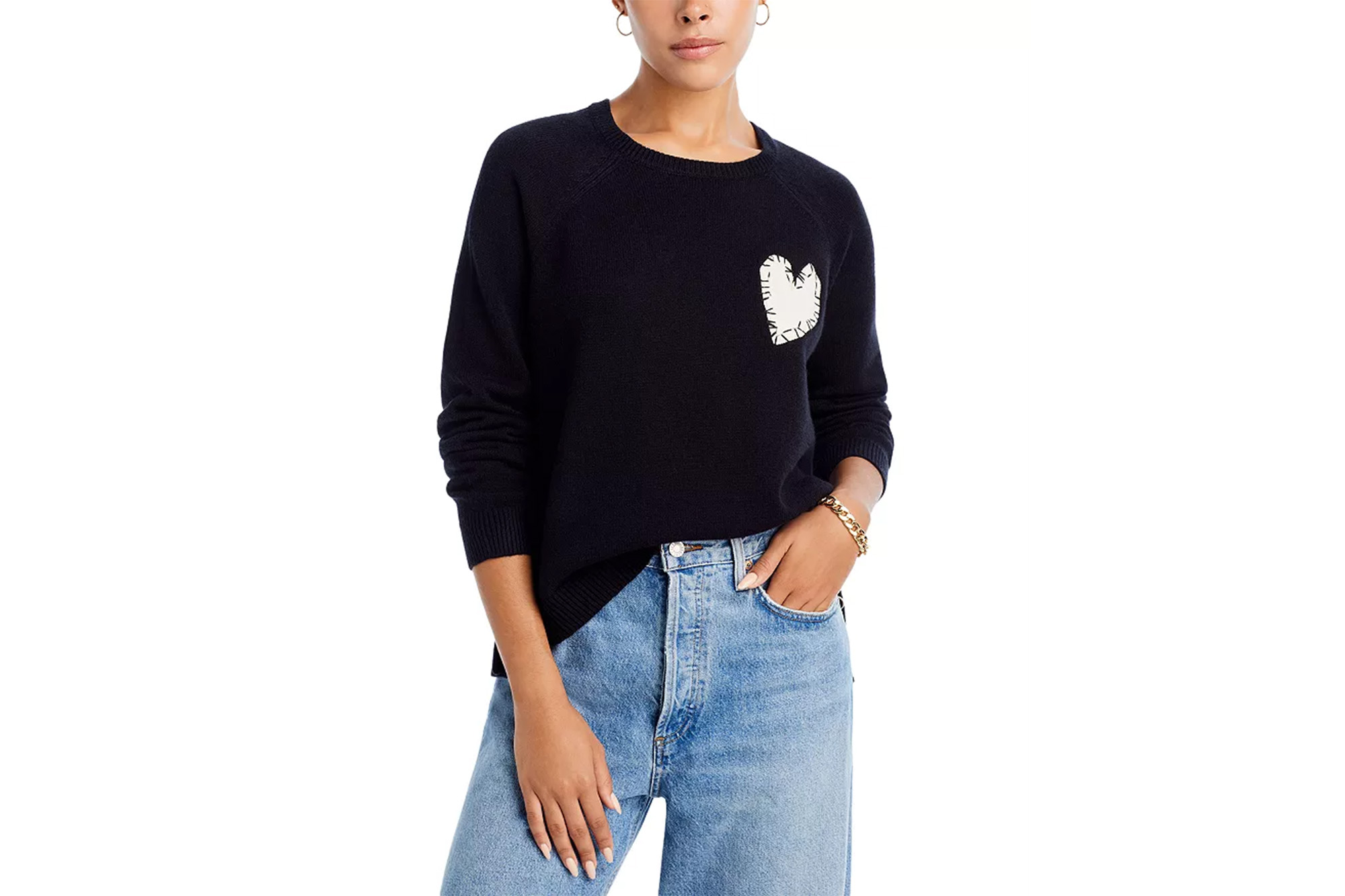 Ein Model in einem schwarzen Pullover mit weißem Herzaufnäher 