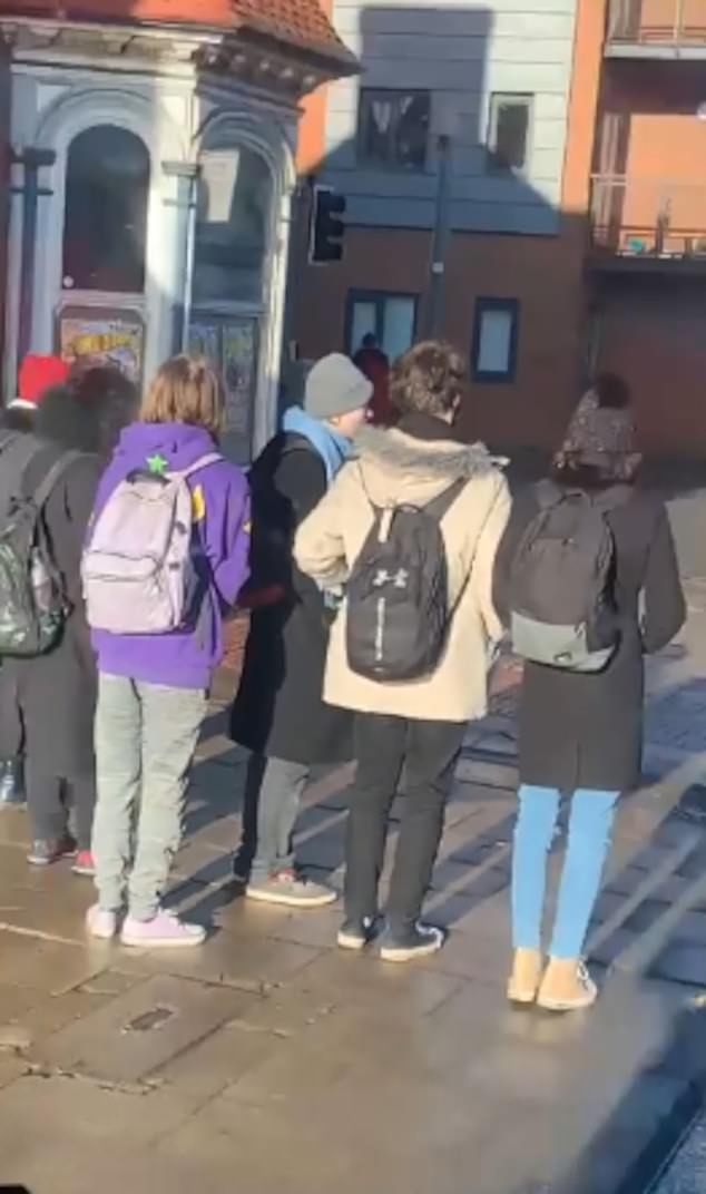Die namenlose Gruppe wurde dabei gefilmt, wie sie ziemlich verwirrt auf dem Bürgersteig stand, als die Ampel auf Rot schaltete