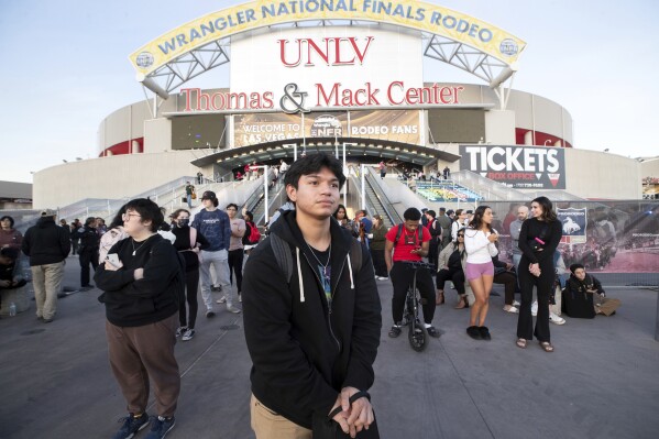 Oscar Hernandez, Mitte, Student der University of Nevada, Las Vegas, wartet nach einer tödlichen Schießerei am Mittwoch, dem 6. Dezember 2023, in Las Vegas auf einen Bus, der ihn vom Campus bringt.  (Steve Marcus/Las Vegas Sun über AP)
