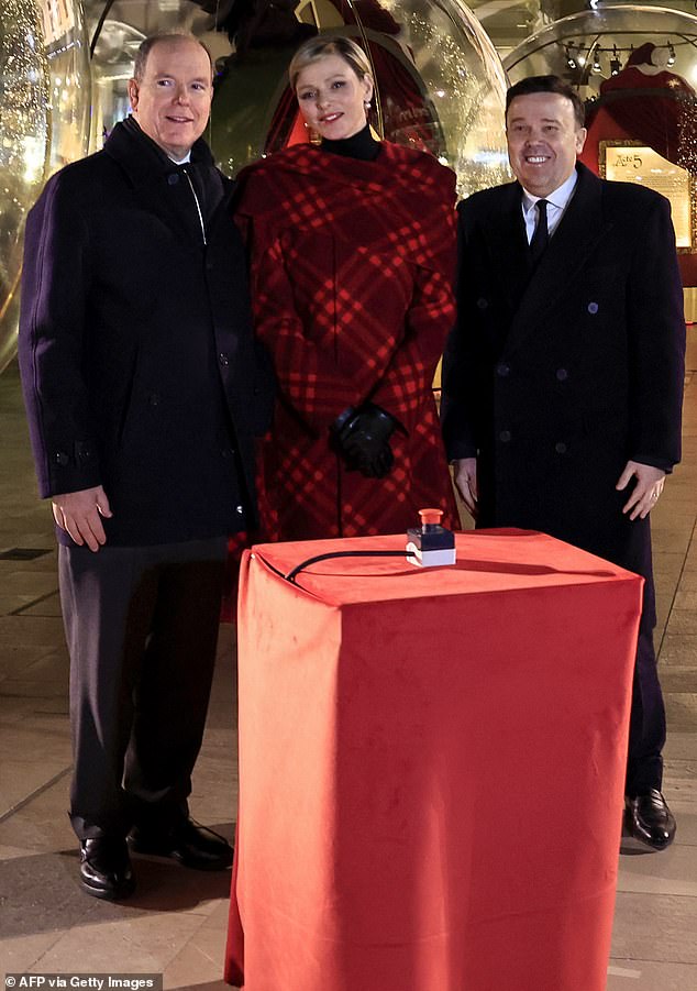 Prinz Albert von Monaco (Bild links) und Prinzessin Charlène von Monaco (Bild Mitte) mit dem Präsidenten der Monte-Carlo Societe des Bains de Mer (SBM) Stephane Valeri (Bild rechts), während sie während der Amtseinführung für ein Foto posieren des Weihnachtsdorfes in Monaco, am 7. Dezember