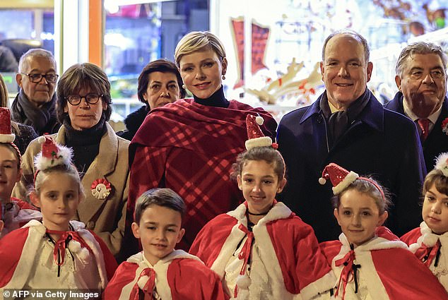Die Royals sind während der festlichen Veranstaltung mit Kindern abgebildet, die während der Veranstaltung Weihnachtsmann-Outfits tragen