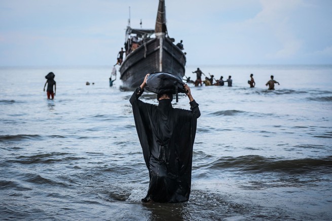 Eine Rohingya-Frau geht in Ulee Madon, Indonesien, zum Strand, nachdem die örtliche Gemeinde einem Flüchtlingsboot vorübergehend erlaubt hat, an Land zu gehen, um Wasser und Nahrung zu holen.