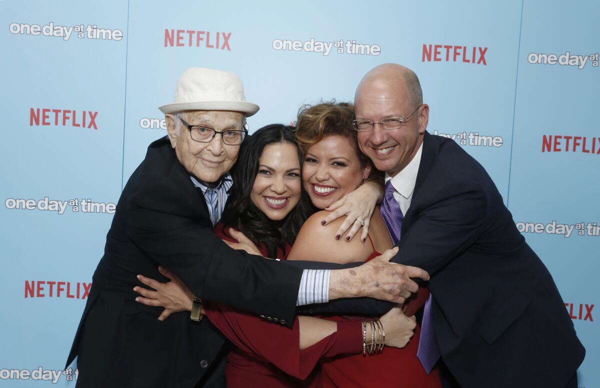 Norman Lear, Gloria Calderon Kellett, Justina Machado und Mike Royce umarmen sich bei einer Netflix-Veranstaltung.
