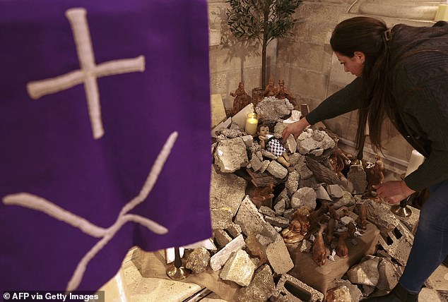 In einer Kirche wurde eine Szene der Geburt Christi mit einer Figur installiert, die „das Jesuskind symbolisiert, das in seiner Krippe inmitten von Trümmern liegt“.