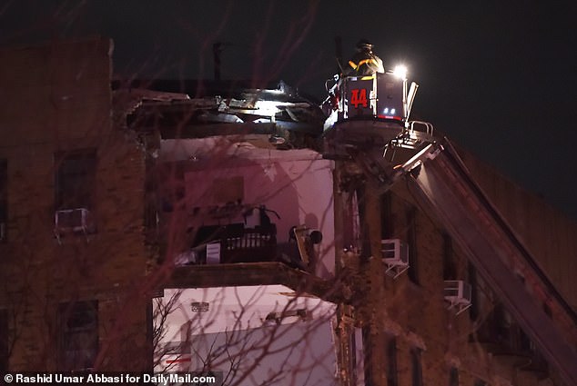Man sieht einen Feuerwehrmann, der in die jetzt freigelegten Wohnungen in der Bronx späht