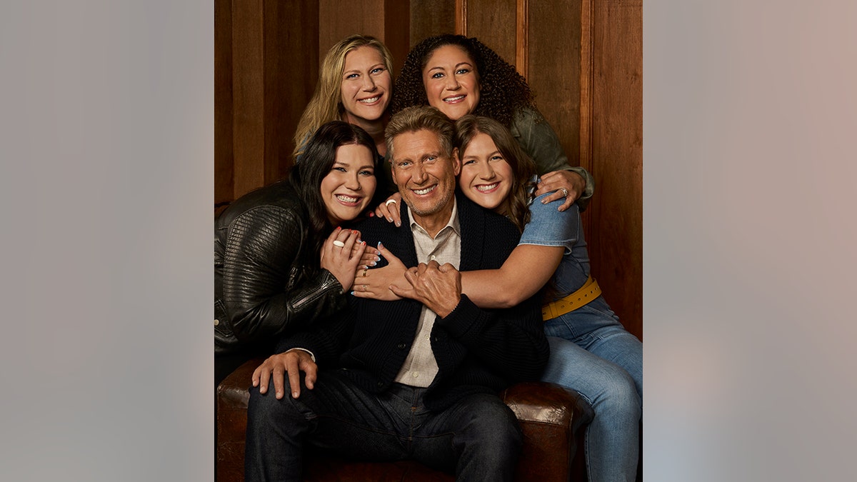 Gerry Turner wird auf einem Familienfoto von seinen beiden Enkelinnen und Töchtern umarmt