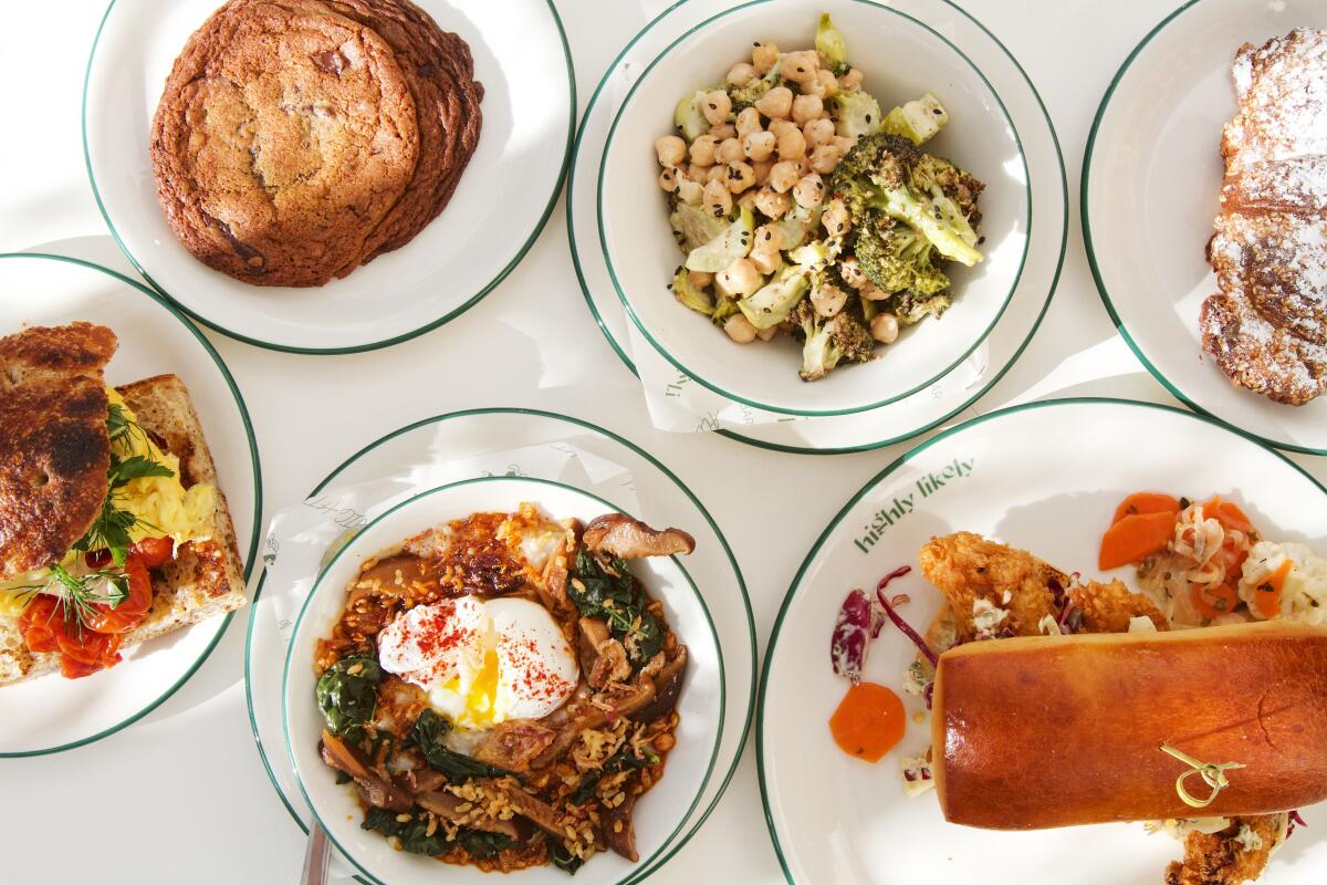 Ein Foto von oben mit Gerichten aus dem ganztägig geöffneten Café Highly Likely auf einer weißen Tischplatte: gebratenes Fischsandwich, Reisschüssel und mehr.