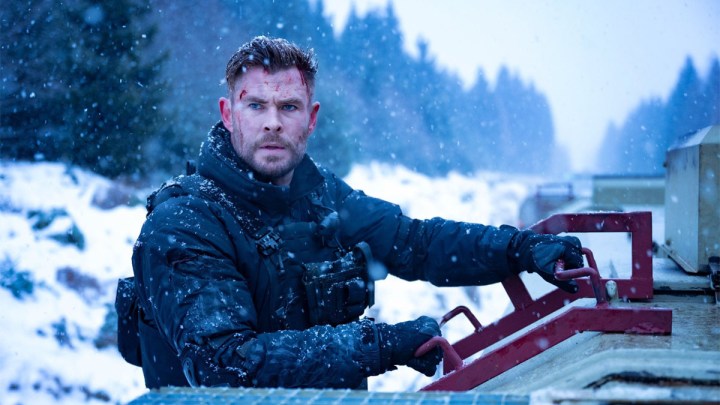 Chris Hemsworth als Tyler Rake blickt in Extraction 2 auf einem Schneefahrzeug in die Ferne.