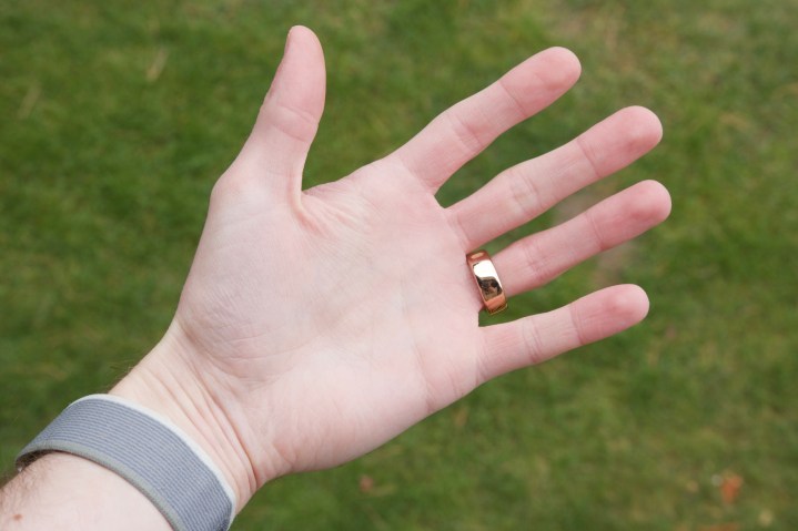 Ein Oura Ring Horizon aus Roségold am Ringfinger einer Person.
