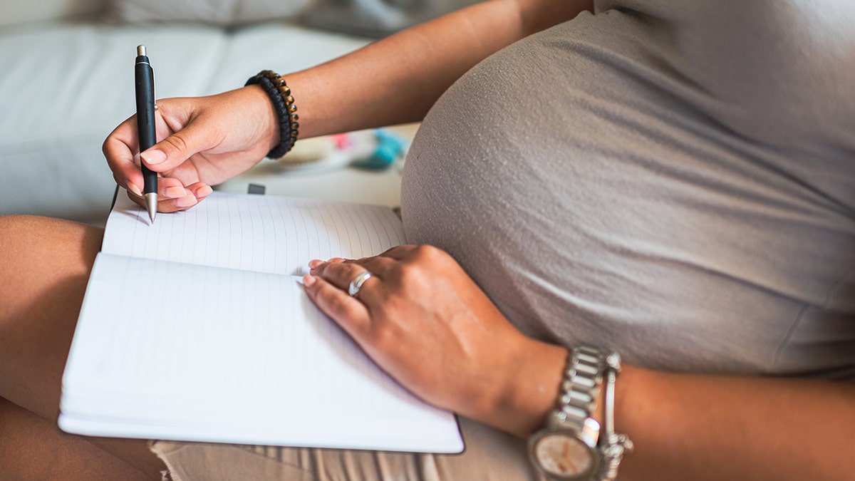 Schwangere Mutter schreibt Liste mit Babynamen
