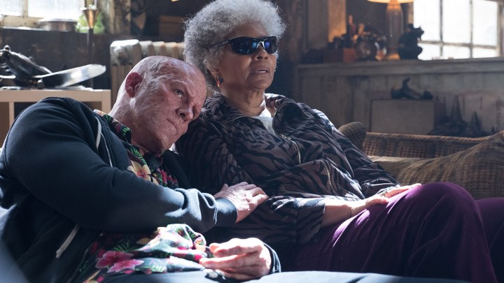 Ryan Reynolds und Leslie Uggams als Deadpool und Blind Al sitzen auf einer Couch, während Deadpool seinen Kopf an Al's Schulter lehnt, in Deadpool 2.