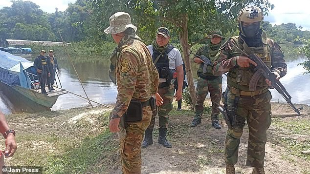 Peru's National Prosecutor's Office, which is investigating the flying 'alien' attacks, has pointed the finger at these illegal gold-mining 'mafias' which were ejected from Brazil and Colombia. Above, armed Peruvian officials arrive at the rural Ikitu community in Alto Nanay to investigate