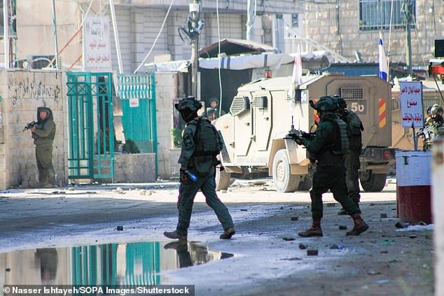 Nach einem israelischen Einfall in das Flüchtlingslager Dschenin in dieser Woche nehmen israelische Soldaten ihre Stellungen ein