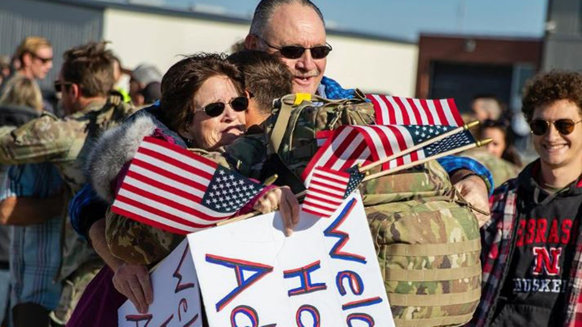 Familie umarmt Soldaten, der vom Einsatz zurückkehrt