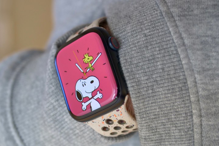Eine Person, die die Apple Watch Series 9 trägt und das Snoopy-Zifferblatt zeigt