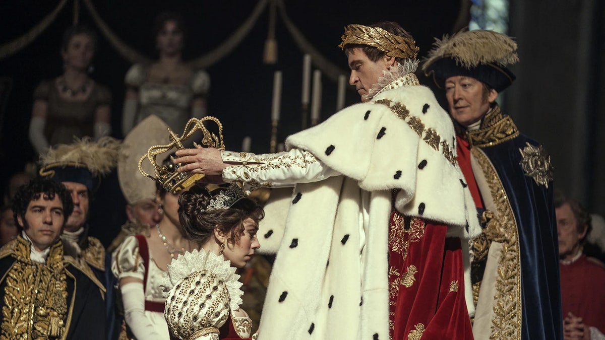 Joaquin Phoenix setzt Vanessa Kirby als Napoleon Bonaparte eine Krone auf den Kopf