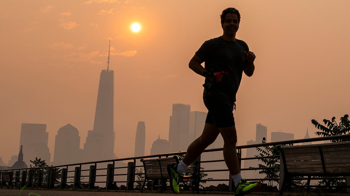 Ein Mann joggt durch den Liberty State Park, während der Rauch der kanadischen Waldbrände den Stadtteil Manhattan bedeckt
