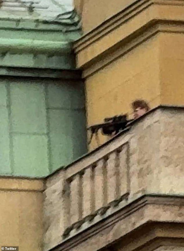 A chilling image shared on local media purports to show the man dressed in black aiming a rifle at people below while standing on top of a faculty building, with witnesses saying the gunman was picking off his victims one by one