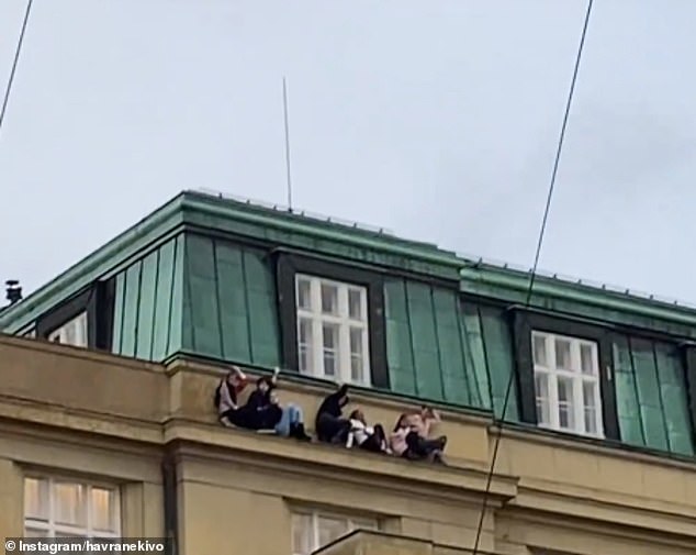 Other extraordinary images show terrified students cowering on a ledge high up on a faculty in a bid to hide from the gunman after others were told to barricade themselves in classrooms