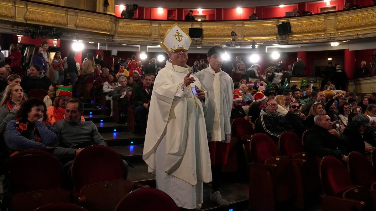 Menschen in Kostümen warten in einem Theater auf den Beginn der spanischen Weihnachtsverlosung.