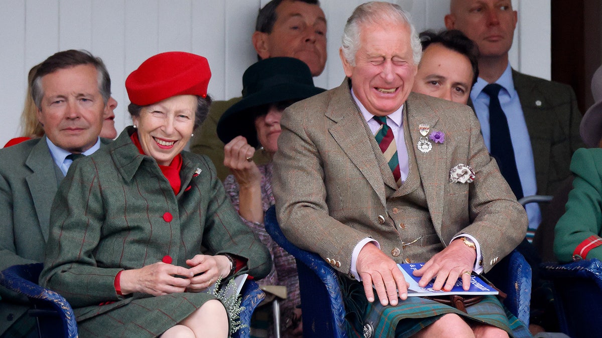 König Charles und Prinzessin Anne sitzen nebeneinander und lachen, während sie passende Outfits tragen