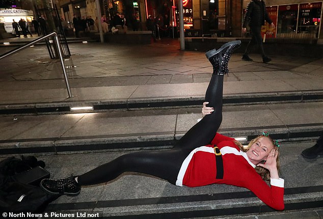 Eine Frau in Newcastle posiert im Zentrum von Newcastle und trägt ein Weihnachtsmannkostüm
