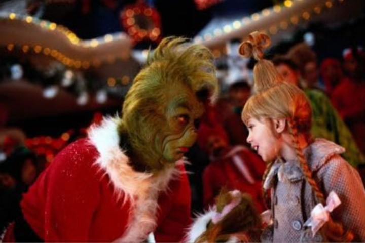 The Grinch and Cindy Lou Who talk while standing next to each other.