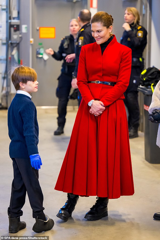 Prinzessin Victoria trug ihre rote Kombination über einem schwarzen Rollkragenpullover und fügte einen schmalen Taillengürtel und klobige Stiefeletten hinzu, um den wintertauglichen Look zu vervollständigen