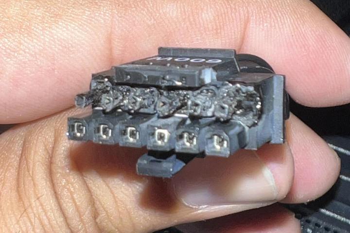 Eine Person hält die Anschlüsse eines Nvidia 12VHPWR-Kabels einer RTX 4090-Grafikkarte.  Die Enden der Steckverbinder sind verbrannt und geschmolzen, da das Kabel überhitzt ist.