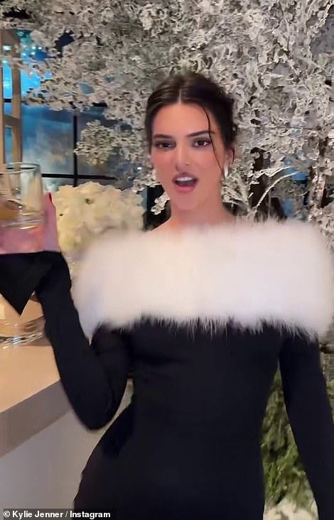 Kendall posed with a glass as she donned a black number with a furry white detailing