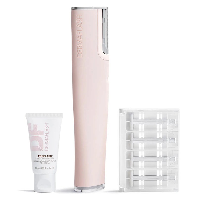 Dermaflash Luxe+: Ein rosafarbenes Dermaplanning-Hautpflegegerät neben einer Packung Dermaplanng-Rasierer und einer kleinen rosa-weißen Tube auf weißem Hintergrund