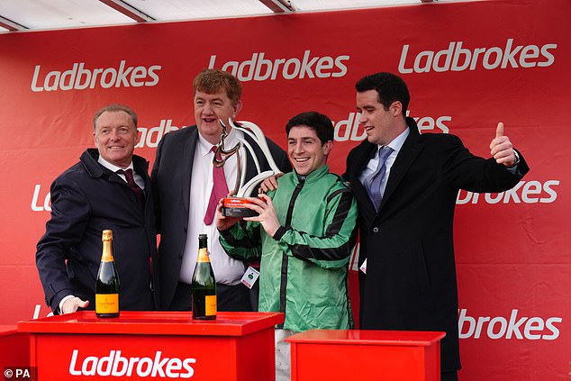 Jockey Gavin Sheehan (Zweiter von rechts) feiert Hewicks Sieg beim Ladbrokes King George VI Chase zusammen mit Trainer John „Shark“ Hanlon (Zweiter von links) und Besitzer TJ McDonald (rechts)