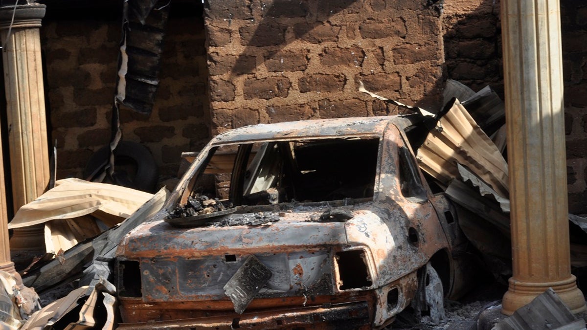 Ein verbranntes Fahrzeug in einem ausgebrannten nigerianischen Haus