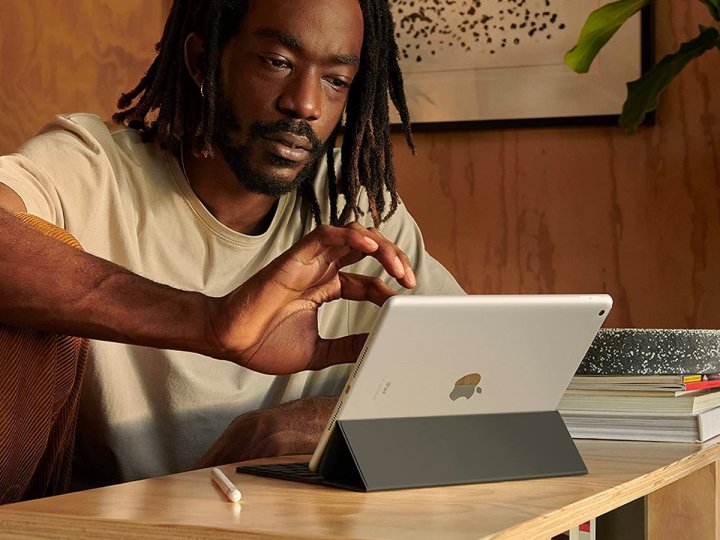 Ein Mann arbeitet an seinem Schreibtisch am Apple iPad 2021.