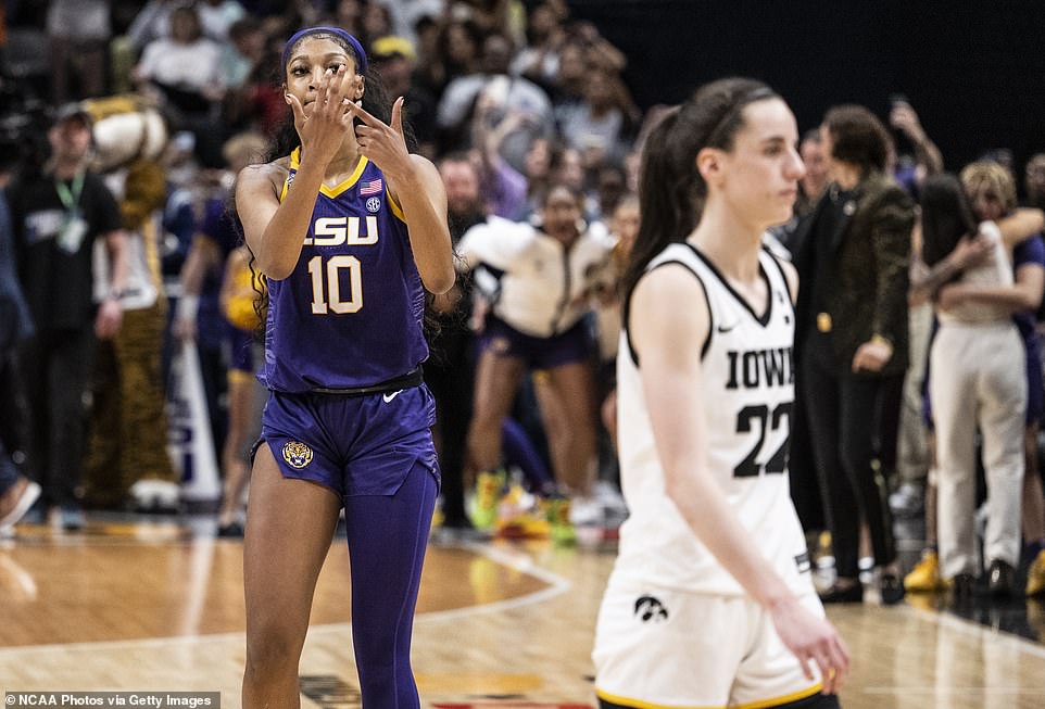 LSU's Angel Reese gestures to her own ring finger as Iowa's Caitlin Clark walks off the court during her NCAA tourney loss