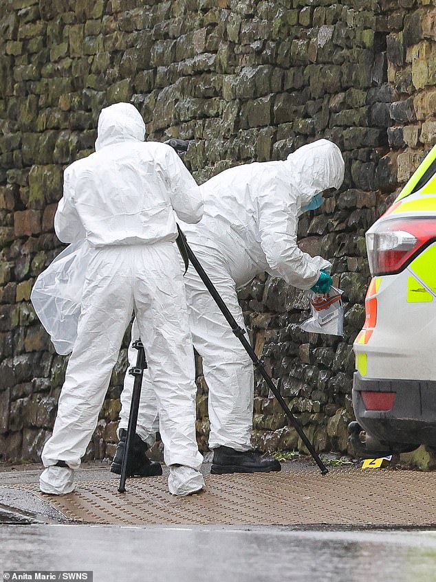 Mr Marriott left his two sons, aged eight and six, to help the lady, who was lying unconscious in the street just after 2pm. Police believe she had been involved in the altercation. Pictured: Forensic officers near to the scene