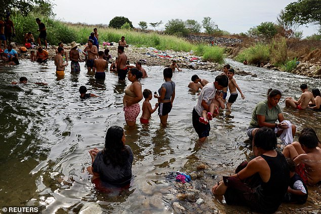 Migranten, die in einer Karawane über Mexiko an die US-Grenze reisen, baden am Freitag in einem Fluss in Mapastepec, Mexiko