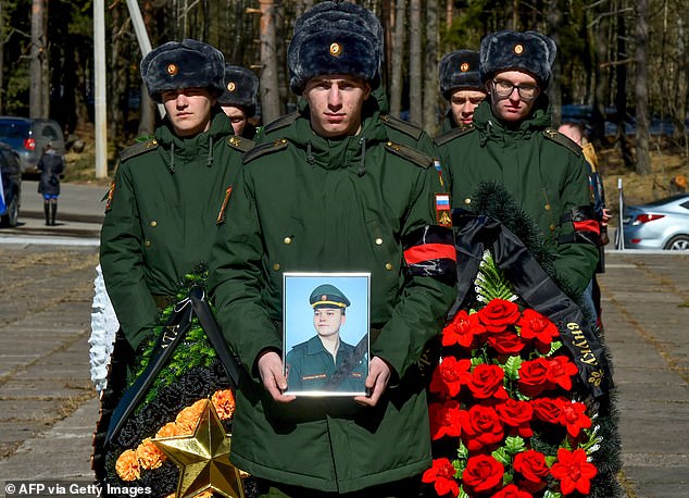 Russische Soldaten tragen Kränze und ein Bild des 20-jährigen russischen Soldaten Nikita Avrov während seiner Beerdigung in Luga, etwa 150 km südlich von Sankt Petersburg, am 11. April 2022. Der Soldat wurde nach der Machtübernahme des russischen Präsidenten Wladimir Putin im Jahr 2000 geboren