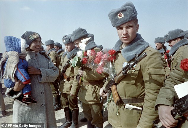 Soldaten der Roten Armee werden in Termez, Usbekistan, mit Blumen begrüßt, nachdem sie am 15. Februar 1989 während des Abzugs der sowjetischen Armee aus Afghanistan den Fluss Amu Darya an der sowjetisch-afghanischen Grenze überquert haben