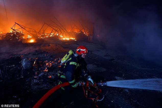 Ein Feuerwehrmann arbeitet auf dem Gelände eines Lagerhauses, das am 29. Dezember 2023 bei einem russischen Raketenangriff in Kiew schwer beschädigt wurde