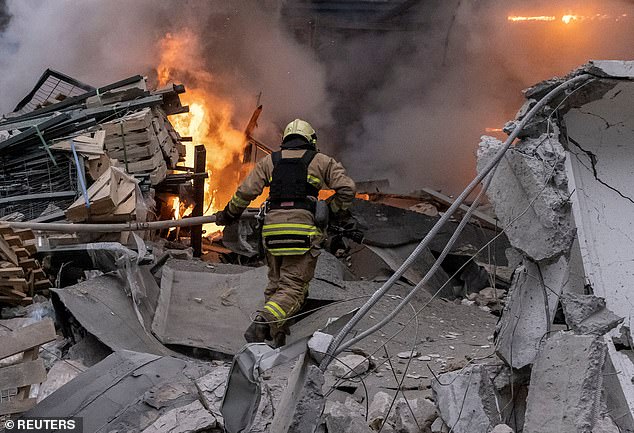 Ein Feuerwehrmann arbeitet am 29. Dezember 2023 am Ort eines russischen Raketenangriffs in Charkiw, Ukraine