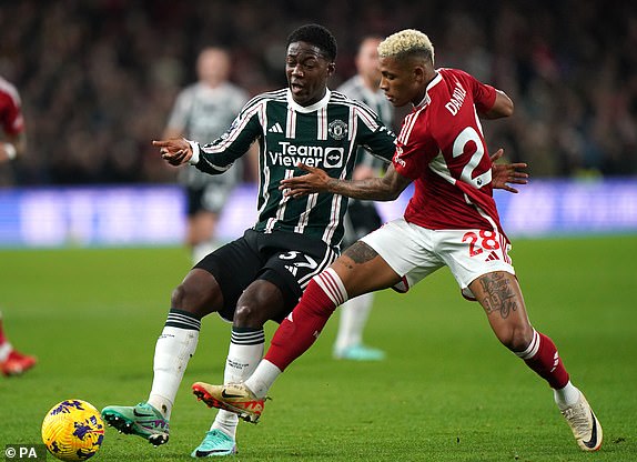 Manchester United's Kobbie Mainoo (left) and Nottingham Forest's Danilo battle for the ball during the Premier League match at the City Ground, Nottingham. Picture date: Saturday December 30, 2023. PA Photo. See PA story SOCCER Forest. Photo credit should read: Bradley Collyer/PA Wire.RESTRICTIONS: EDITORIAL USE ONLY No use with unauthorised audio, video, data, fixture lists, club/league logos or "live" services. Online in-match use limited to 120 images, no video emulation. No use in betting, games or single club/league/player publications.