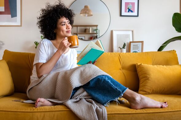 Entspannte Frau liest zu Hause ein Buch