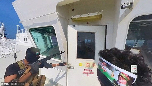 Houthi-Kämpfer öffnen im November die Tür des Cockpits auf dem Deck des Galaxy Leader-Schiffes im Roten Meer