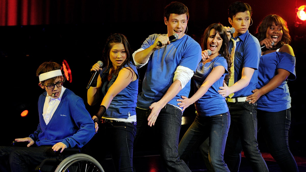 Cory Monteith acting with his castmates in a scene for Glee
