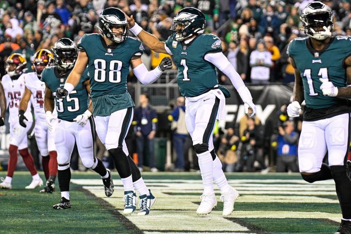 Three Eagles players celebrate in the end zone.